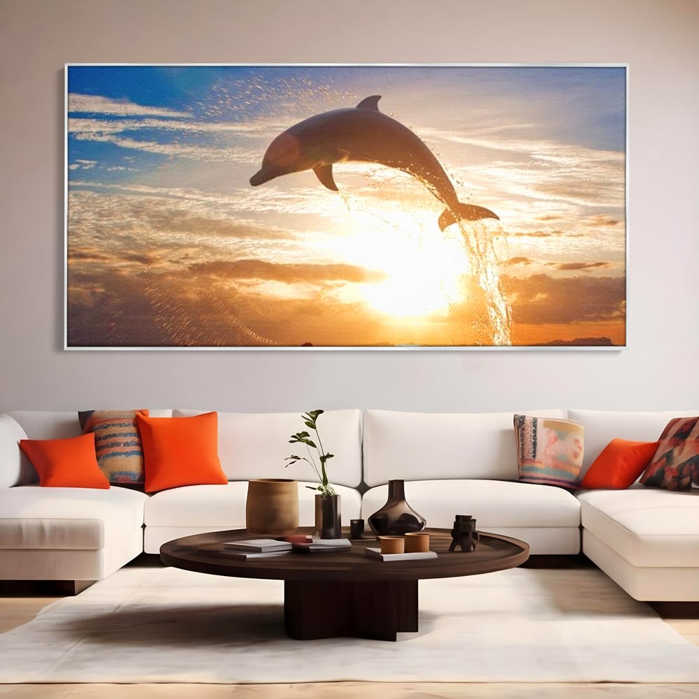 Tablou canvas cu delfin care sare la apus, in rama de aluminiu argintiu, pe perete intr-un living